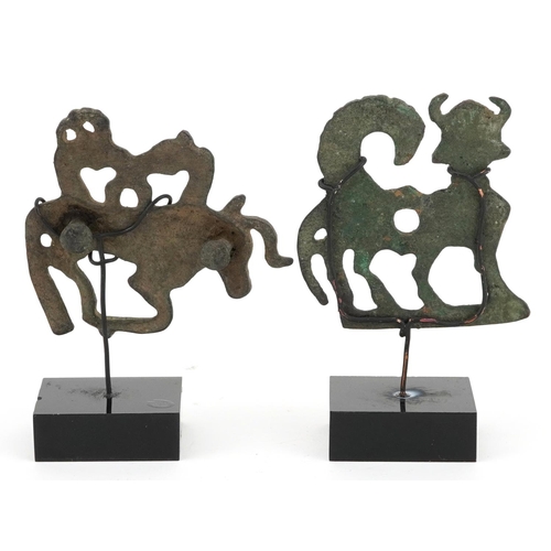 388 - Two Persian Luristan patinated mythical animal bronzes including a handle, each raised on stands, th... 