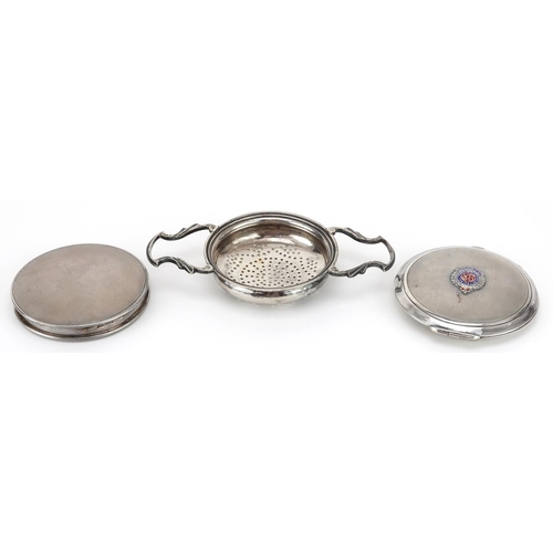 270 - Two circular silver compacts and a silver strainer by Goldsmiths & Silversmiths Co, one with militar... 