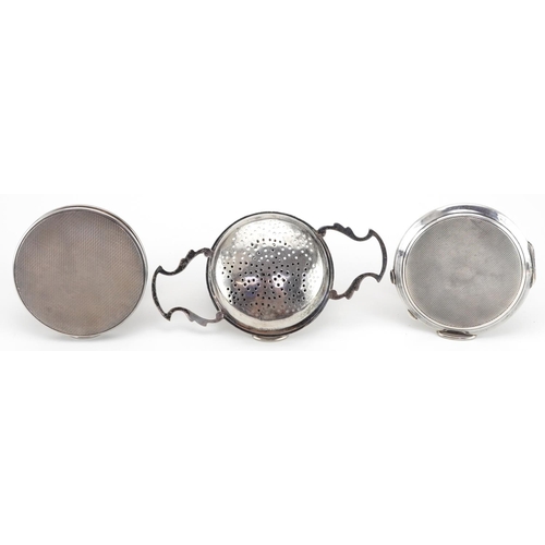 270 - Two circular silver compacts and a silver strainer by Goldsmiths & Silversmiths Co, one with militar... 