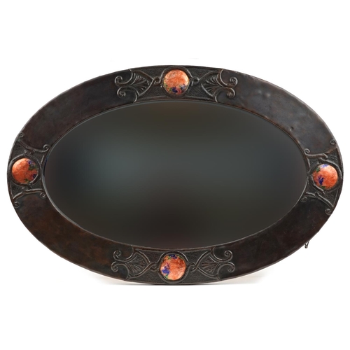 102 - Attributed to Liberty & Co, Arts & Crafts copper wall mirror with bevelled glass having four Ruskin ... 