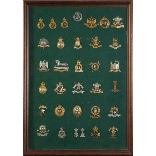 2412 - Military interest cap badges arranged in a glazed display including 14th King's Hussars, 16th The Qu... 