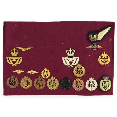 2410 - Military interest cap badges, shoulder titles and cloth badges arranged on a sheet, predominantly Ro... 