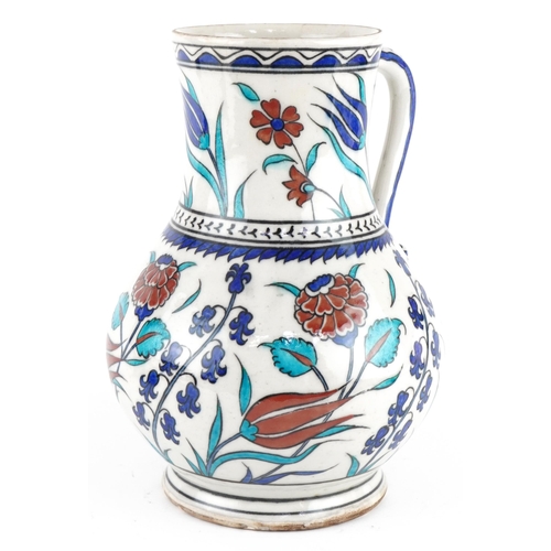 85 - Turkish Ottoman Iznik pottery handled vessel hand painted with stylised flowers, 25cm high