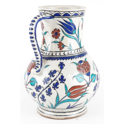 85 - Turkish Ottoman Iznik pottery handled vessel hand painted with stylised flowers, 25cm high