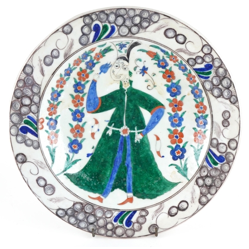 377 - Turkish Ottoman Iznik pottery shallow dish hand painted with a figure wearing traditional dress amon... 