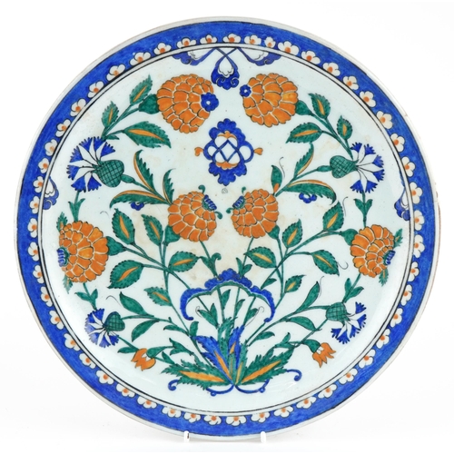 86 - Turkish Ottoman Iznik pottery plate hand painted with stylised flowers, 30cm in diameter