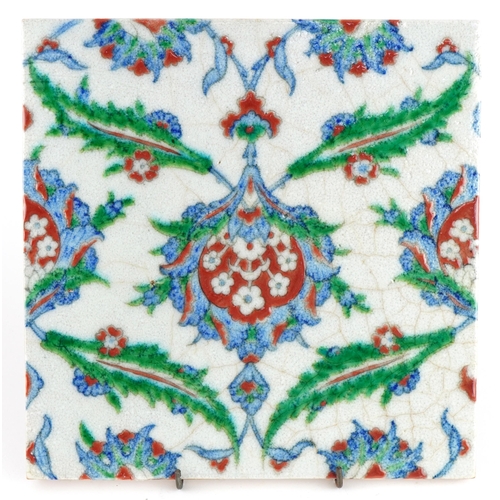 87 - Turkish Ottoman Iznik pottery tile hand painted with stylised flowers, 25cm x 25cm