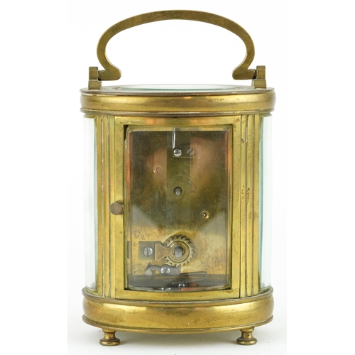 135 - 19th century oval brass cased carriage clock with enamelled dial having Roman numerals, 11.5cm high ... 
