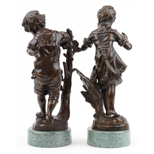 18 - After Auguste Moreau, pair or classical patinated bronze figures of a young boy and girl, each raise... 
