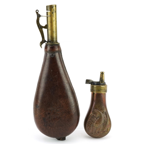 2473 - Two antique brass mounted powder flasks including one with copper body embossed with an eagle, the l... 