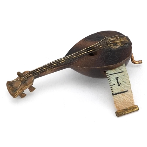 370 - 19th century novelty metal tape measure in the form of a mandolin, 7cm in length