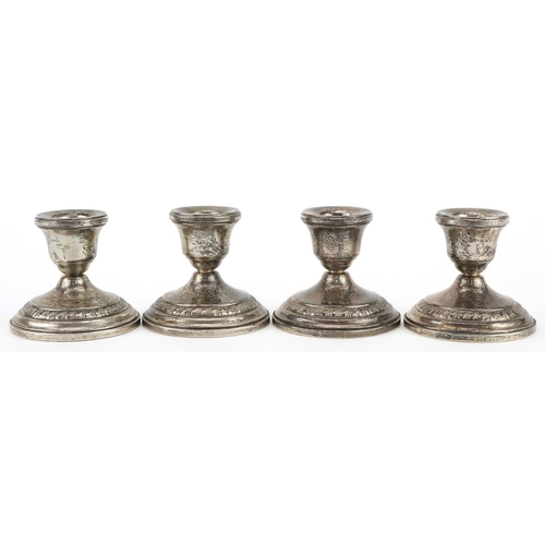 334 - Columbia, set of four circular sterling silver  weighted dwarf candlesticks, 8cm in diameter, total ... 