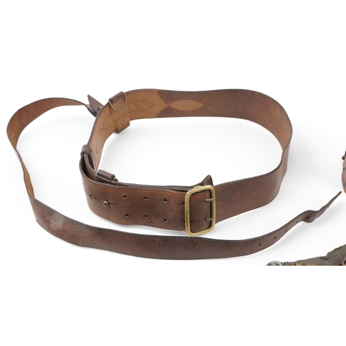 2434 - Militaria including brown leather Sam Browne and canvas belt with various cap badges including Tynes... 