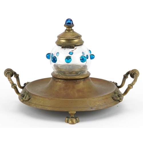 143 - Victorian aesthetic brass desk stand with handles and glass inkwell, 19cm wide