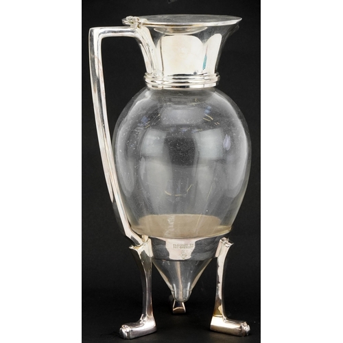 109 - Manner of Christopher Dresser, silver plated and glass three footed claret jug, 26cm high