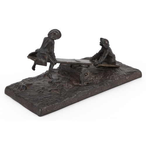 274 - Victorian bronzed cast metal letter clip in the form of two figures on a see-saw, 17cm wide