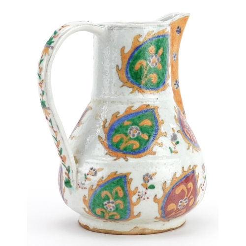 427 - Turkish Ottoman Kutahya porcelain water jug hand painted with stylised flowers within leaves, 19cm h... 