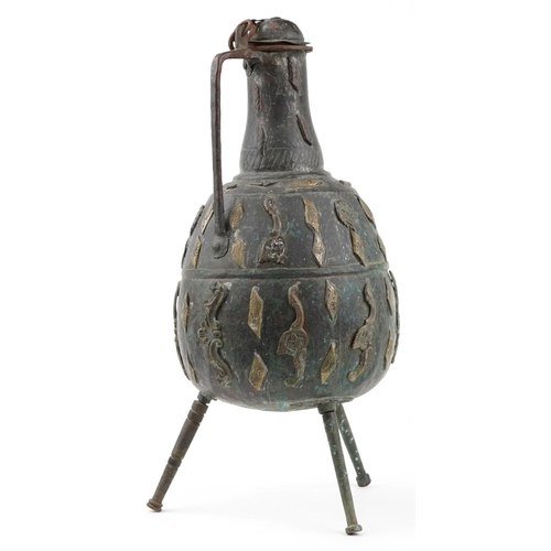 437 - Large Middle Eastern patinated bronze three footed handled vessel, 64cm high