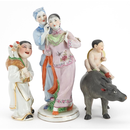 494 - Three Chinese porcelain figures including one of a nude box on water buffalo and a Chinese Revolutio... 