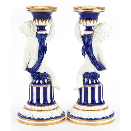 159 - Mintons, pair of aesthetic porcelain Putti candlesticks, impressed marks and numbers to the bases, e... 