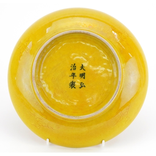 498 - Chinese porcelain yellow ground shallow dish incised under glaze with a dragon amongst clouds, six f... 