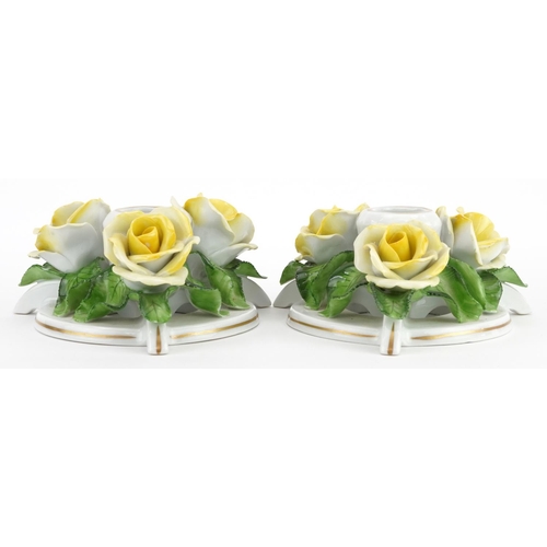 635 - Herend, pair of Hungarian floral encrusted porcelain candlesticks, each 13.5cm in diameter