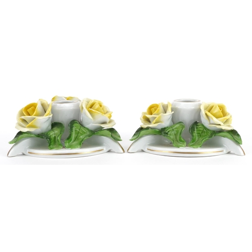 635 - Herend, pair of Hungarian floral encrusted porcelain candlesticks, each 13.5cm in diameter