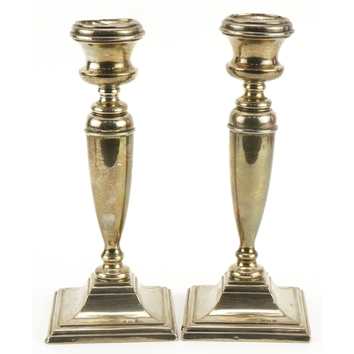 192 - Pair of George V silver candlesticks with square stepped bases, indistinct maker's mark Birmingham 1... 