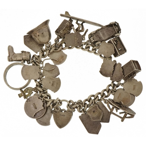 3233 - Heavy silver charm bracelet with a large selection of mostly silver charms, some opening, including ... 