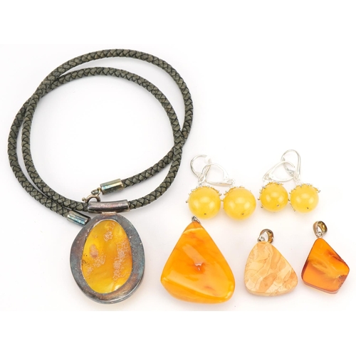 3809 - Amber jewellery comprising two pendants, one on chain and four pairs of earrings