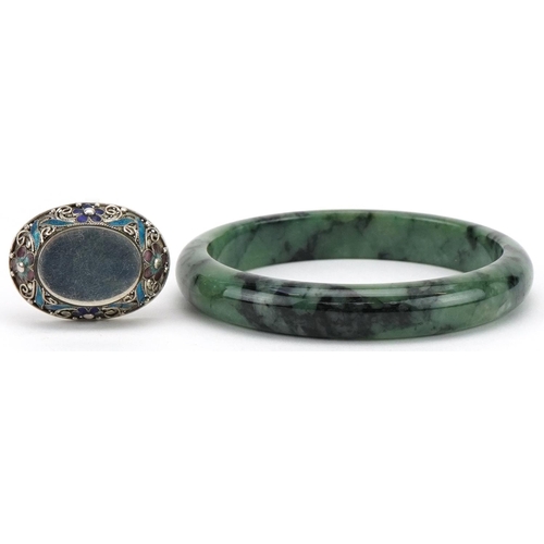 3798 - Chinese green jade bangle and silver and enamel brooch, the bangle 7cm in diameter