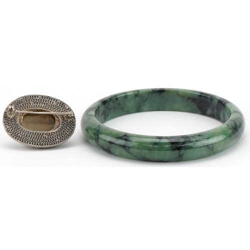 3798 - Chinese green jade bangle and silver and enamel brooch, the bangle 7cm in diameter