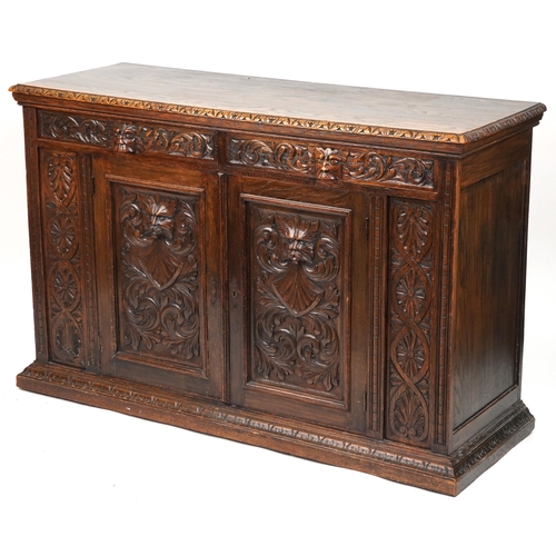 1019 - Victorian oak sideboard fitted with two frieze drawers above cupboard base carved with masks amongst... 