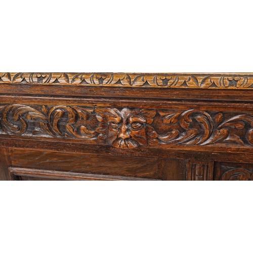 1019 - Victorian oak sideboard fitted with two frieze drawers above cupboard base carved with masks amongst... 