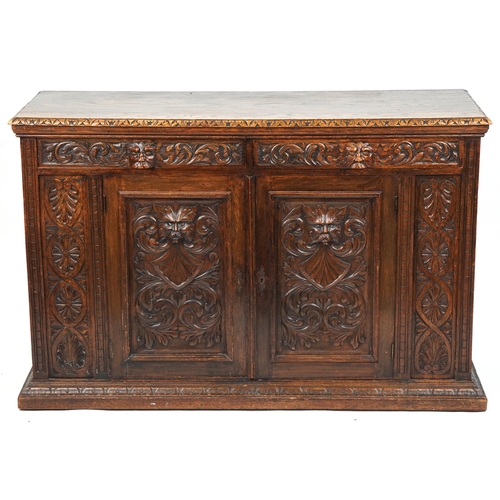 1019 - Victorian oak sideboard fitted with two frieze drawers above cupboard base carved with masks amongst... 