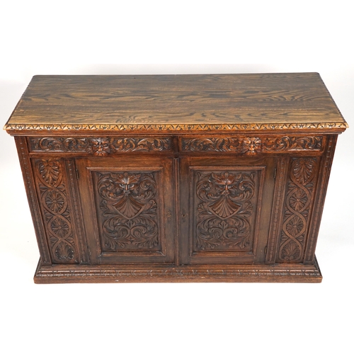 1019 - Victorian oak sideboard fitted with two frieze drawers above cupboard base carved with masks amongst... 