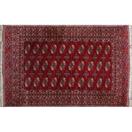 1030 - Rectangular Persian red ground rug having an allover repeat floral design, 190cm x 120cm