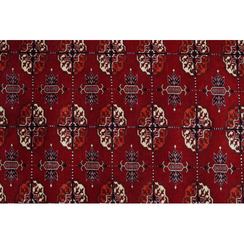 1030 - Rectangular Persian red ground rug having an allover repeat floral design, 190cm x 120cm