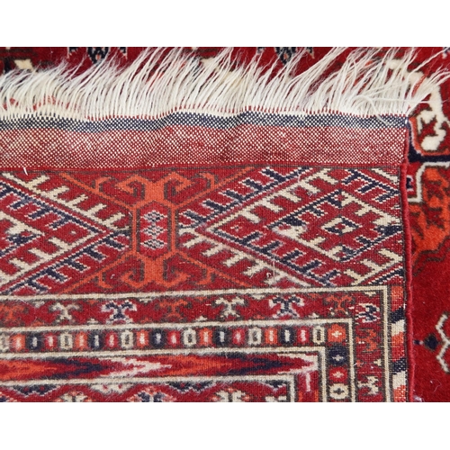 1030 - Rectangular Persian red ground rug having an allover repeat floral design, 190cm x 120cm