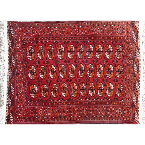 1010 - Rectangular Persian red ground rug having an allover repeat design, 170cm x 120cm