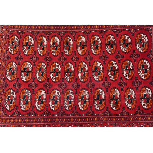 1010 - Rectangular Persian red ground rug having an allover repeat design, 170cm x 120cm