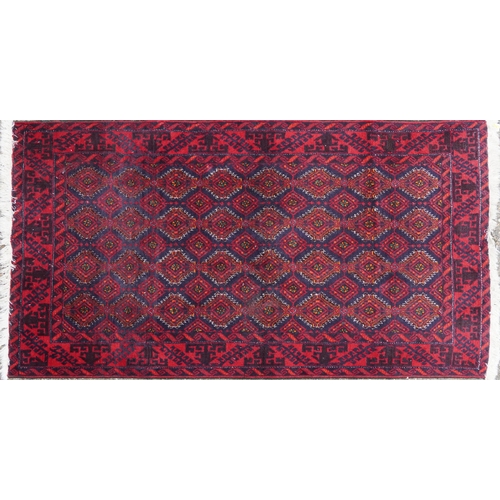 1015 - Rectangular Persian red ground rug having an allover repeat design within a geometric border, 190cm ... 