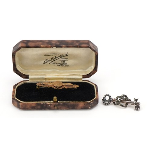 3201 - Silver marcasite key brooch and Victorian unmarked gold aesthetic bar brooch housed in a Chas. Frank... 