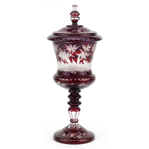 518 - 19th century Bohemian ruby overlaid glass goblet and cover etched with wild animals amongst foliage,... 