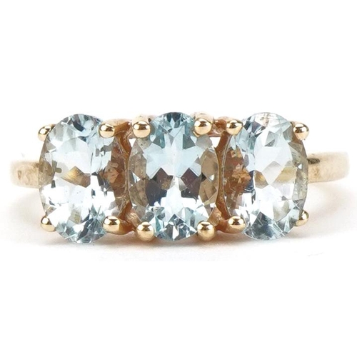 3204 - 10ct gold aquamarine three stone ring, the stones each approximately 7.00mm x 4.90mm x 3.40mm deep, ... 