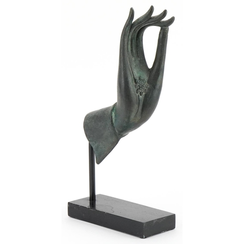 497 - Thai verdigris patinated bronze hand raised on an ebonised stand, overall 32.5cm high