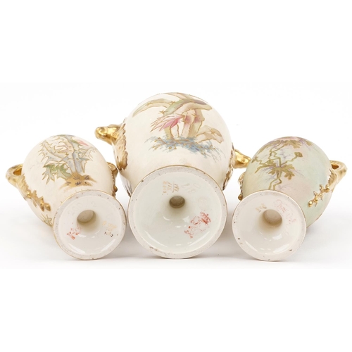 1702 - Royal Bonn, garniture of three blush ivory vases and covers with handles, each decorated with flower... 