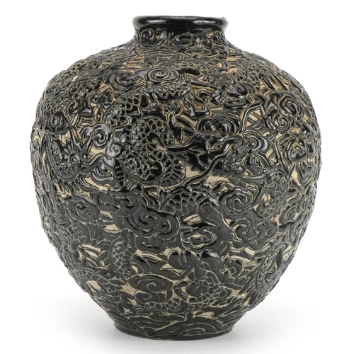 541 - Chinese porcelain vase having a black glaze profusely decorated in relief with dragons amongst cloud... 