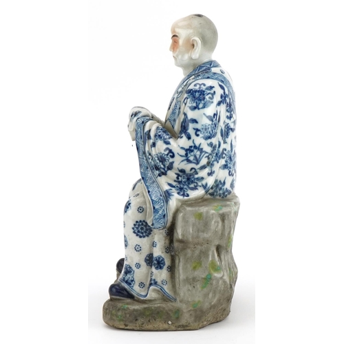 417 - Chinese porcelain figure of an emperor wearing a blue and white robe, hand painted with flower heads... 