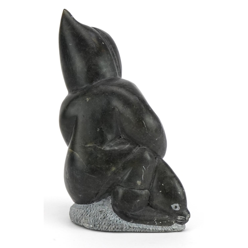 493A - Inuit hardstone carving of an Eskimo, incised marks and paper label to the base, 15cm high